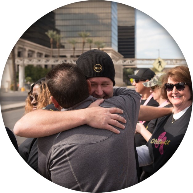 CEO & Founder Kuba Jewgieniew hugging fellow participant in the ONE Walk in Las Vegas, NV