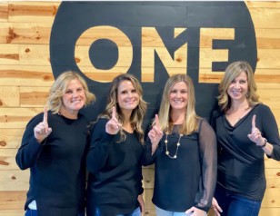 Image of Realty ONE Group professionals holding up the ONE 